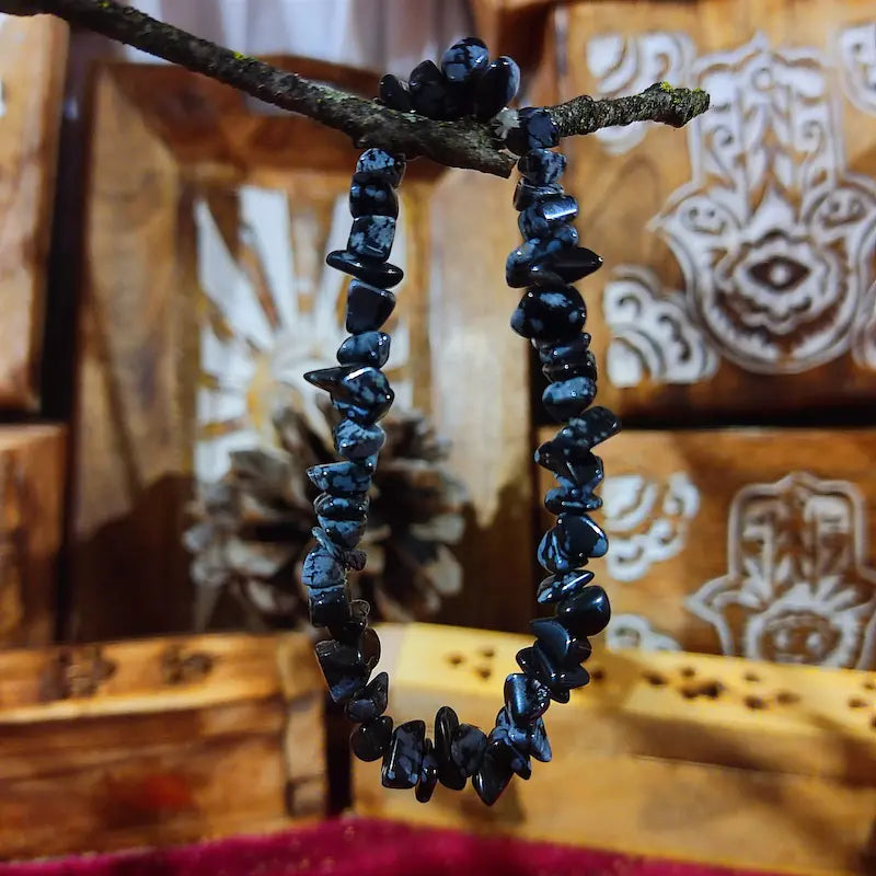Despierta tu autoconocimiento con la Obsidiana Nevada Natural. Con su profundo color negro salpicado de copos blancos, es una potente piedra de crecimiento personal y protección vinculada al primer chakra, invitándote a integrar la luz y hallar la paz interior.