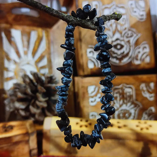 Despierta tu autoconocimiento con la Obsidiana Nevada Natural. Con su profundo color negro salpicado de copos blancos, es una potente piedra de crecimiento personal y protección vinculada al primer chakra, invitándote a integrar la luz y hallar la paz interior.